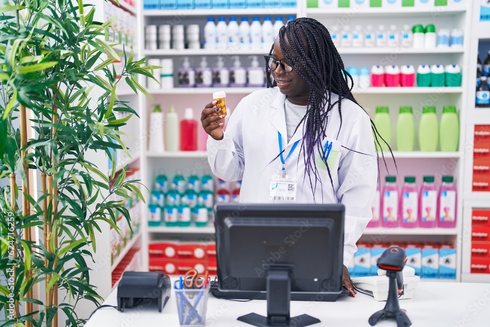 Sticker African american woman pharmacist using computer holding pills bottle at pharmacy