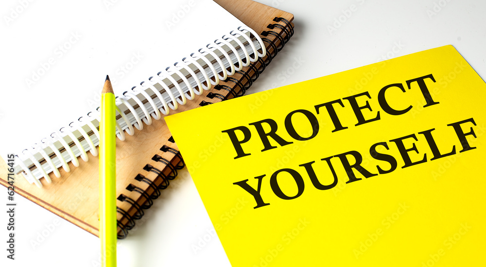 Poster protect yourself text written on a yellow paper with notebook