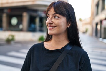 Young beautiful hispanic woman smiling confident looking to the side at street