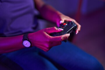 African american woman playing video game using joystick at gaming room