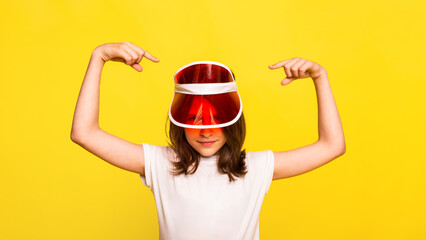 girl points both hands on red visor on her hand. protection from sun in summertime sunny days