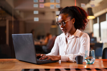 Black businesswoman working on laptop. Portrait of beautiful businesswoman in the office.