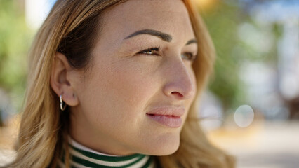 Fototapeta premium Young beautiful hispanic woman standing with serious expression looking to the side at park