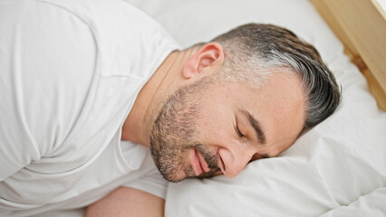 Grey-haired man lying on bed sleeping at bedroom
