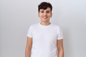 Young non binary man wearing casual white t shirt with a happy and cool smile on face. lucky person.