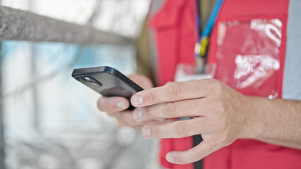 Young caucasian man architect using smartphone at construction place