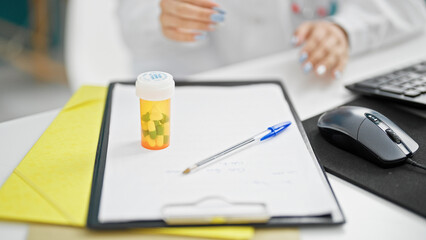 Fototapeta premium Young caucasian woman doctor sitting on table at clinic