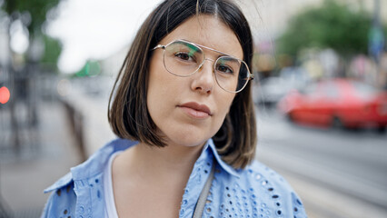 Young beautiful hispanic woman standing with serious expression in the streets of Vienna