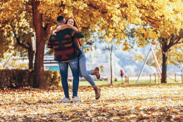Young happy couple having fun in autumn park.