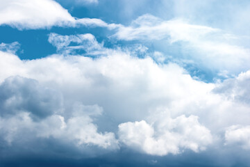 Naklejka na ściany i meble Wispy storm clouds on blue sky. Cloudscape outdoors background.