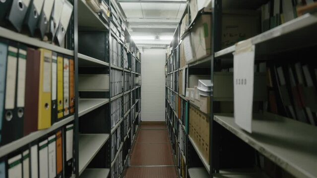 Gang im Dokumentenarchiv im Keller eines alten B&uuml;ros mit Regalen und alten Dokumentenmappen