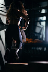 Fototapeta na wymiar Athletic Beautiful Woman jumping Doing her cross fitness at gym