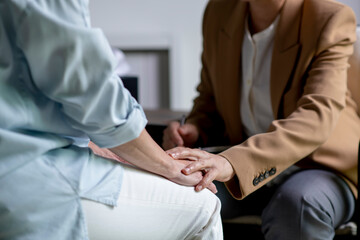 Female therapist, psychologist holding patient’s hand to give support and assurance