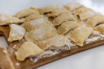 Raw dumpling. Preparation dumplings on a wooden board.