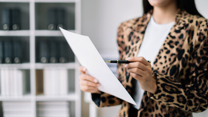 Businesswoman using a tablet and charts to analysis graph company financial in office.