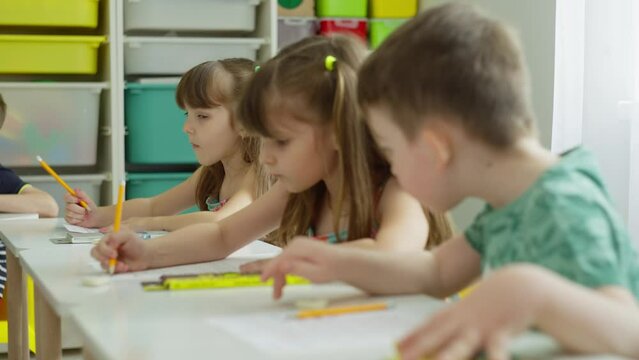 Children study at their desks. The boy is spying on the girl's task. Primary school, first grade. High quality 4k footage