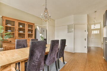 a dining room with chairs and a wooden table in front of the door that leads to an open kitchen area