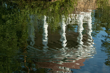 Reflection of the gazebo on the water surface of the pond.