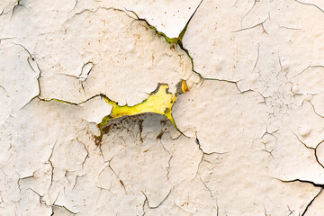 Close up of the colorful cracks and chips of an old wall.