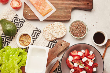 Preparing food for Ketogenic, Paleo, FODMAP diet menu. Smoked salmon, salad with tomato and feta - healthy ingredients