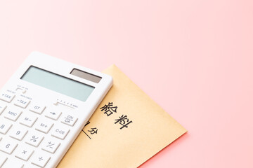 ピンク背景の電卓と給料袋