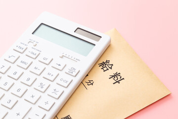ピンク背景の電卓と給料袋