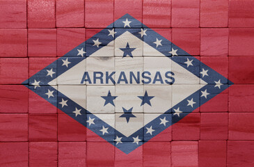 colorful painted big national flag of arkansas state on a wooden cubes texture.