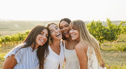 Group of women friends having fun at summer event in countryside with vineyards in background -...