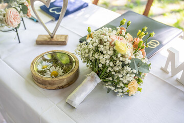 Beautiful wedding table surface with Mr and Miss signs against background bouquet of flowers and wedding rings