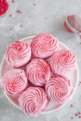 Raspberry zephyr, Russian marshmallows on a cake stand on a grey concrete background. Copy space, selective focus.
