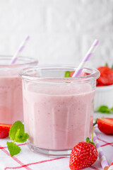 Strawberry milkshake or smoothie cocktail in the glass jar on a gray concrete background. Copy space.