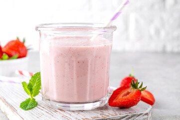 Strawberry milkshake or smoothie cocktail in the glass jar on a gray concrete background. Copy space.