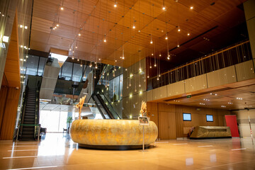 modern hotel interior with round reception desk and sophisticated lobby design, escalators, moving...