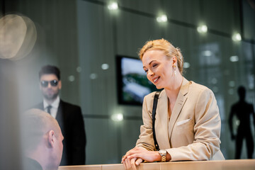 polite businesswoman talking to receptionist in hotel, hospitality industry, blonde and cheerful...