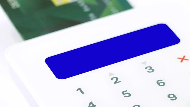 Closeup finger entering pin (personal identification number) for electronic purchasing by credit or debit card blue screen display