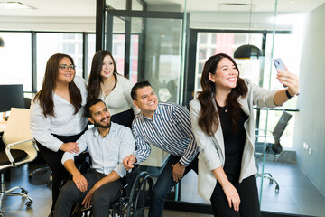 Fototapeta premium Asian woman taking selfie with colleagues in office