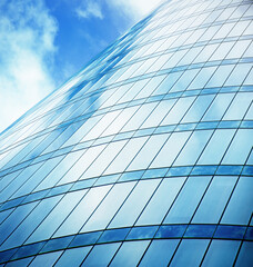 abstract facade of a glazed building and the reflecting sky in it