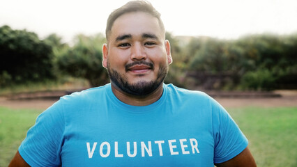 Asian male volunteer working at foundation charity outdoor - Plus size man looking at camera in...