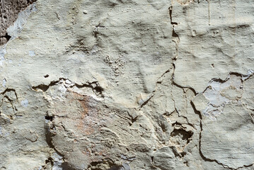 Grey rough cracked plaster wall abstract background.