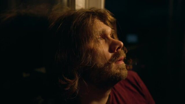 Pensive man looking up lost in thoughts. Introspection and self-analysis. Thinking about life problems. Night window. Depressed man looking upward with hope. Depression man,  doubt, inner conflict