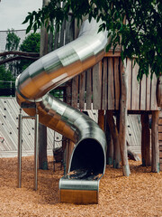 Public children playground constructed with mix of metal and wood elements. Blend of technology,...