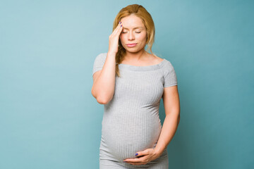 Woman getting a headache during pregnancy and feeling unwell