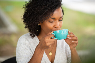 Close up young african american woman drinking of coffee outdoors - Powered by Adobe