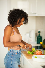 young african american woman cutting food in kitchen