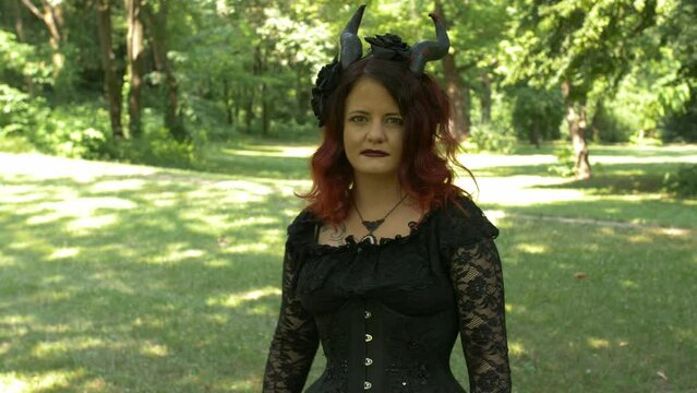 Succubus cosplay girl in the forest moving toward you challenging, Medium Shot Slow Motion.