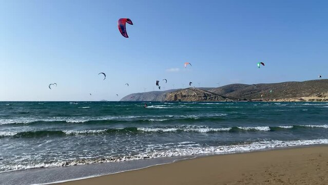 Surfers in Prasonisi Beach in Rhodes island, Greece. Kiteboarder kitesurfer athlete performing kitesurfing kiteboarding tricks. Prasonisi Beach is popular location for surfing. Greece