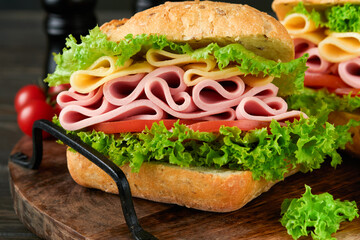 Sandwich. Tasty sandwich with ham or bacon, cheese, tomatoes, lettuce and grain bread on dark...