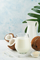 Glass of coconut milk and coconut close up on a white background with space for text. Coconut vegan milk non dairy or Dairy free milk concept. Healthy vegan food.