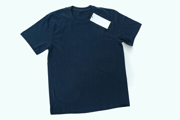 Navy Blue t-shirt laying on the table, top view, full body with a blank sign of the logo hanging.