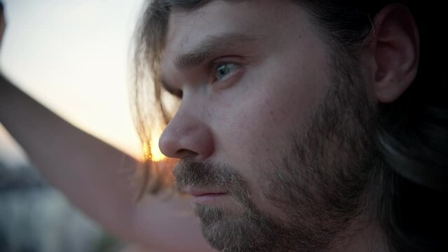 Pensive man lost in thoughts. Introspection and self-analysis. Thinking about life problems. Sunset, sunrise. Depressed man looking with hope. Depression man, doubt, inner conflict